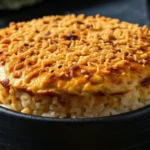 Salmon sushi bake with a golden, crispy topping served in a black dish | TastyTopRecipes.com