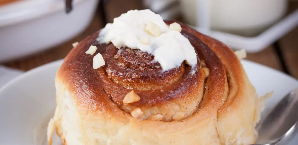 Sourdough Discard Cinnamon Rolls: A Perfect Use for Your Starter A freshly baked tray of Sourdough Discard Cinnamon Rolls, showcasing their golden-brown tops and swirls of cinnamon sugar, drizzled with creamy icing.