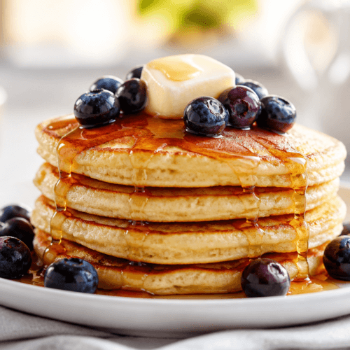Easy gluten free pancakes stacked with maple syrup and fresh berries